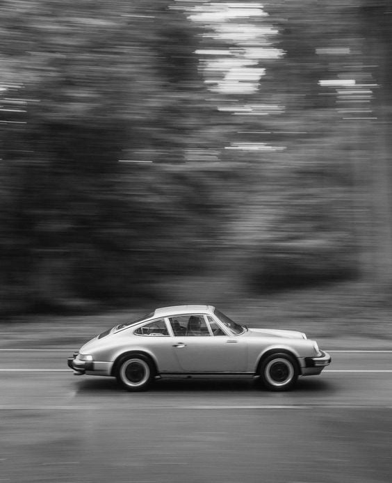 Black and white porsche driving fast